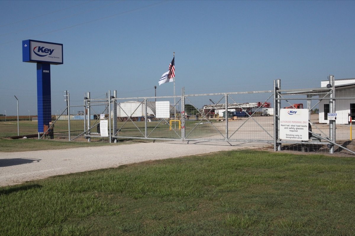 Pipe-frame net wire site perimeter with double drive gates at a Texas energy services yard
