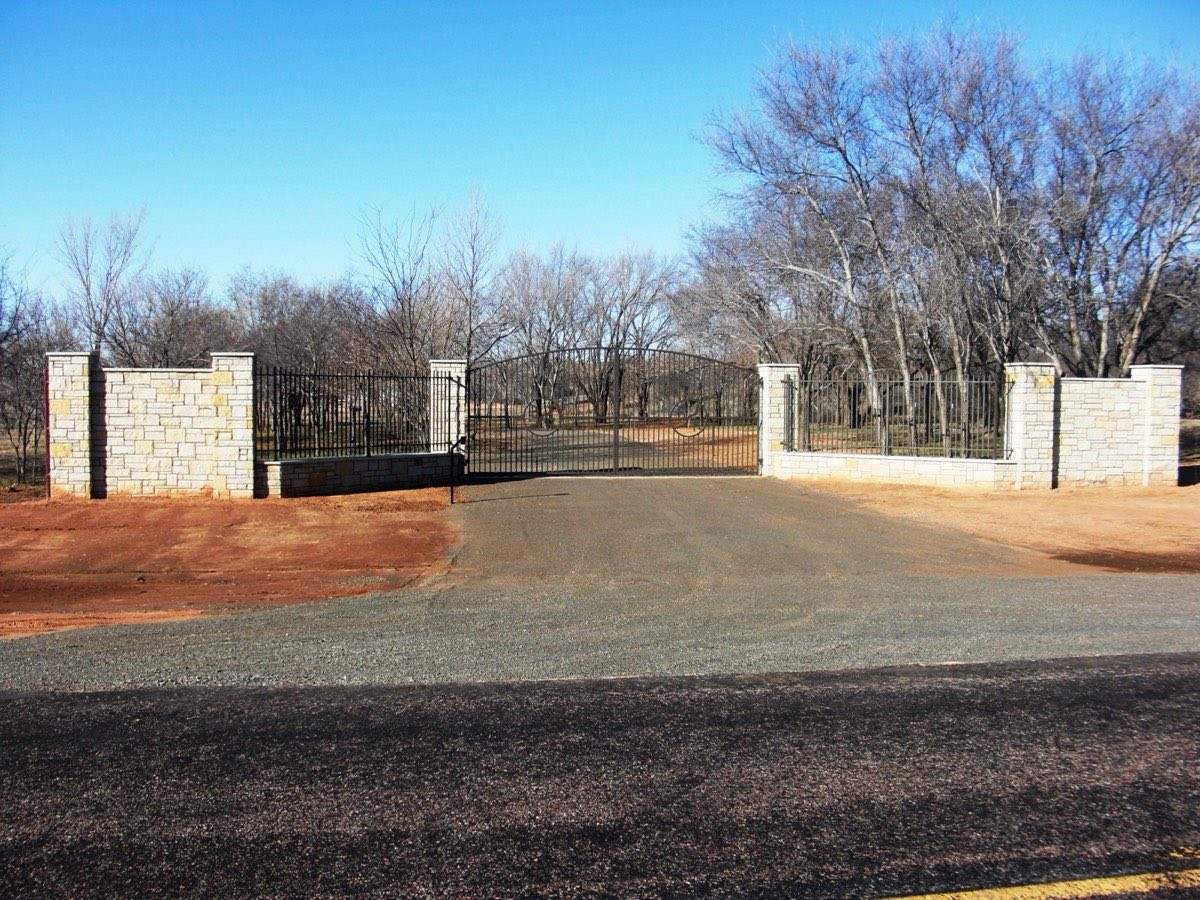 Stone column entry with ornamental fence and double drive-through gates